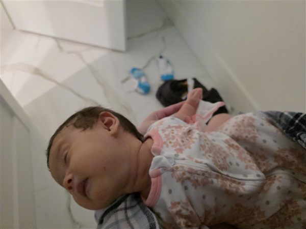 My newborn asleep on my lap in the bathroom